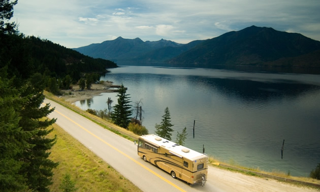 RV driving by beautiful lake