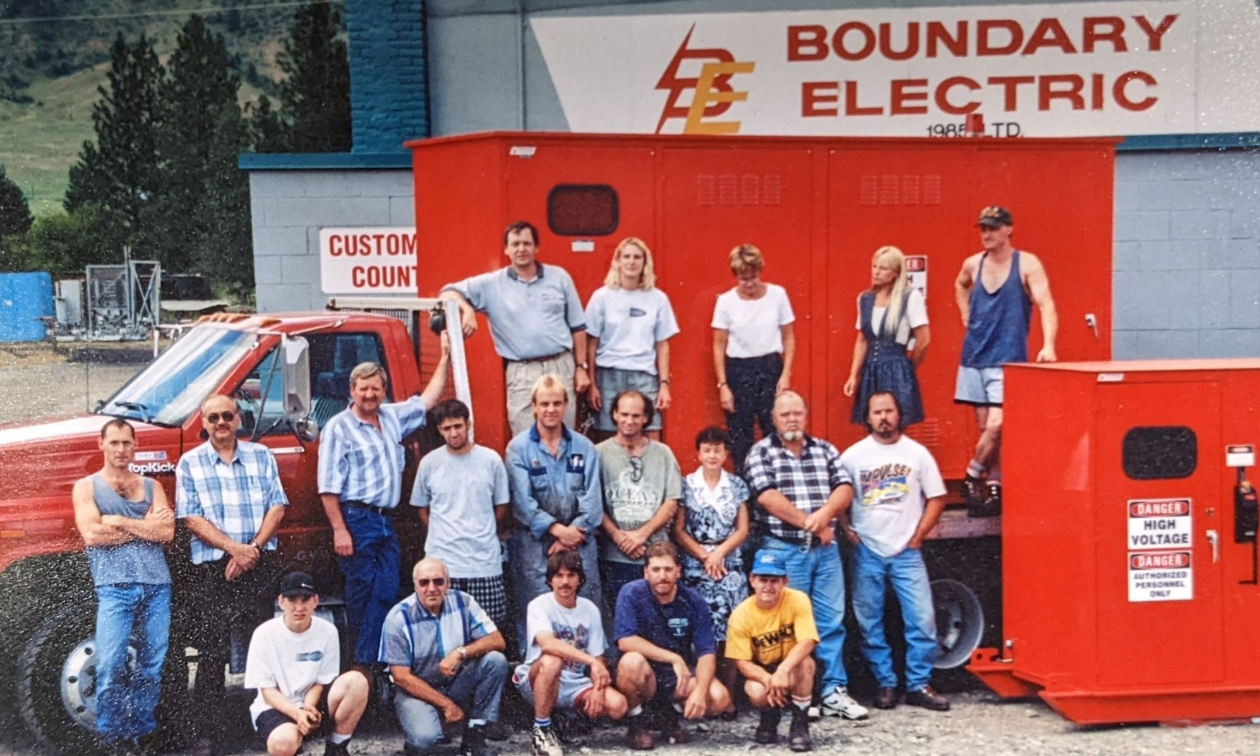 A group of employees pose in front of Boundary Electric in an old photo. 