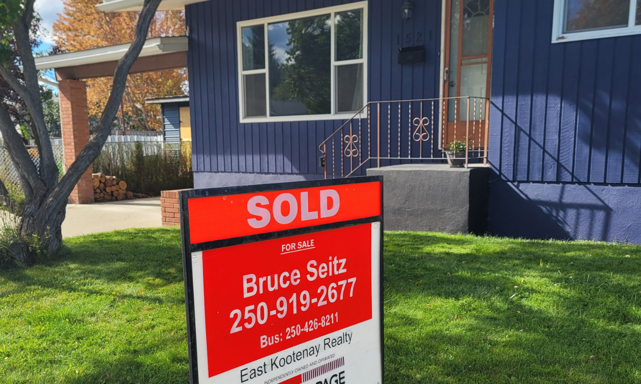 A blue home with a red SOLD sign up front that says Bruce Seitz 250-919-2677.