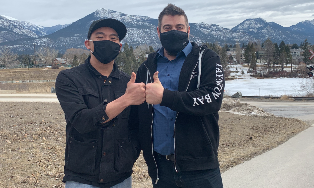 Chris Policar and Ryan “Butter” Karl fist-bump each other while wearing black masks.