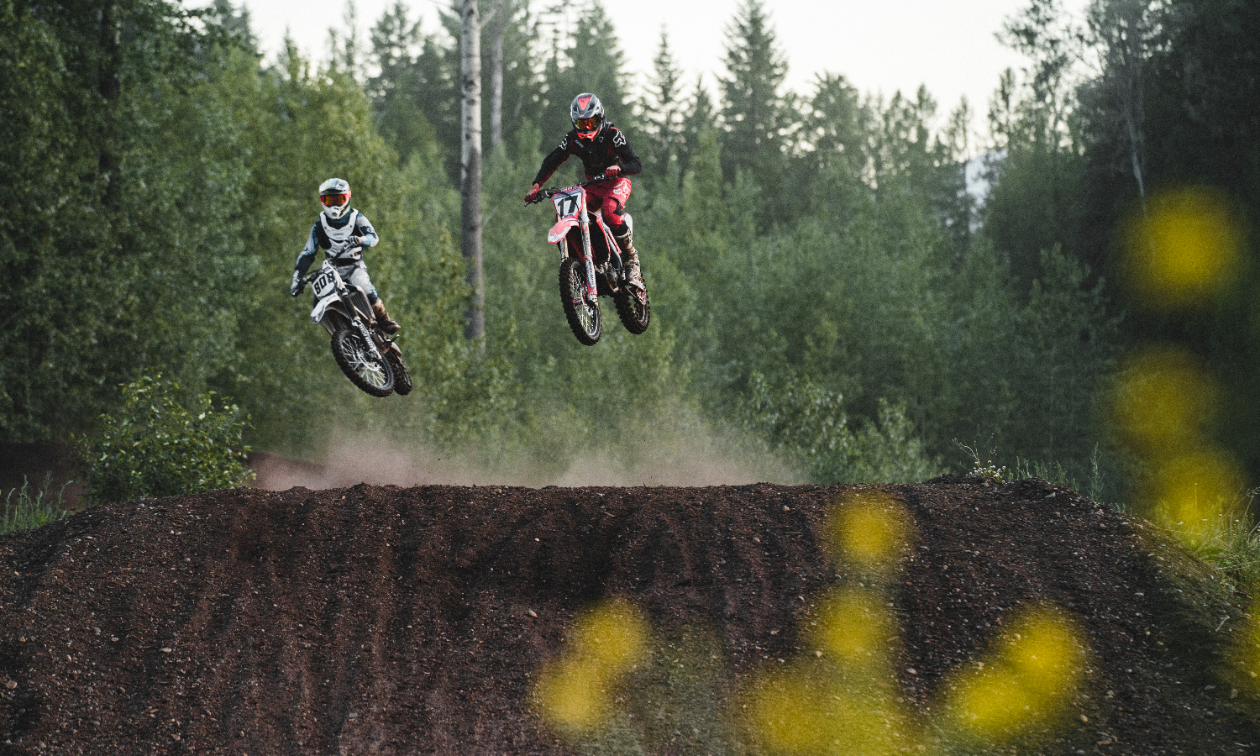 Two dirt bikers get big air off of a jump on the West Kootenay Recreational Dirt Bike and ATV Society motocross track.