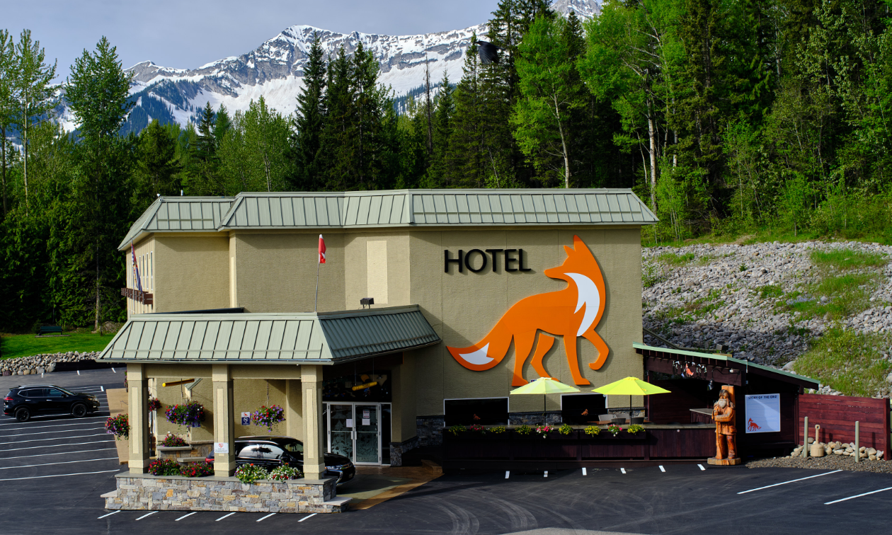 The Fernie Fox Hotel is a big beige building with a large image of an orange fox on the side. 