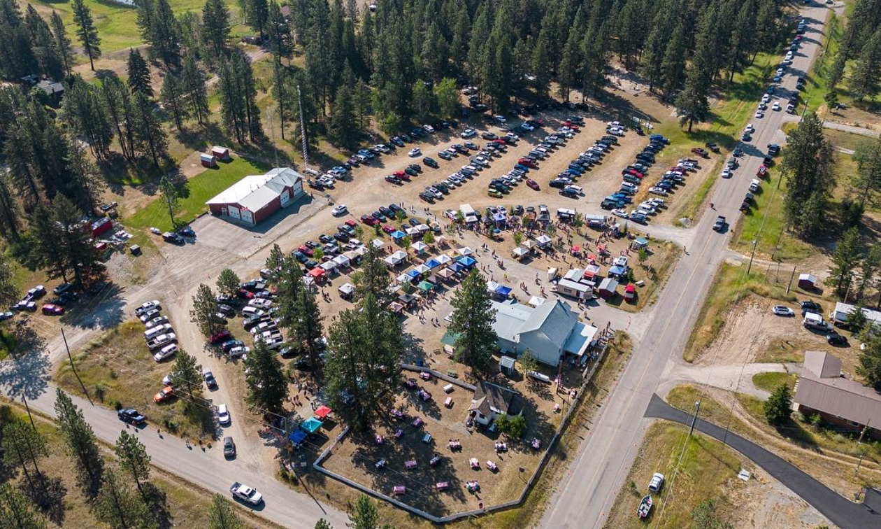 An aerial shot of the Jaffray-Baynes Lake Farmers’ Market shows several rows of tents and vehicle venders forming a quarter-circle around a building and two intersecting roads. 