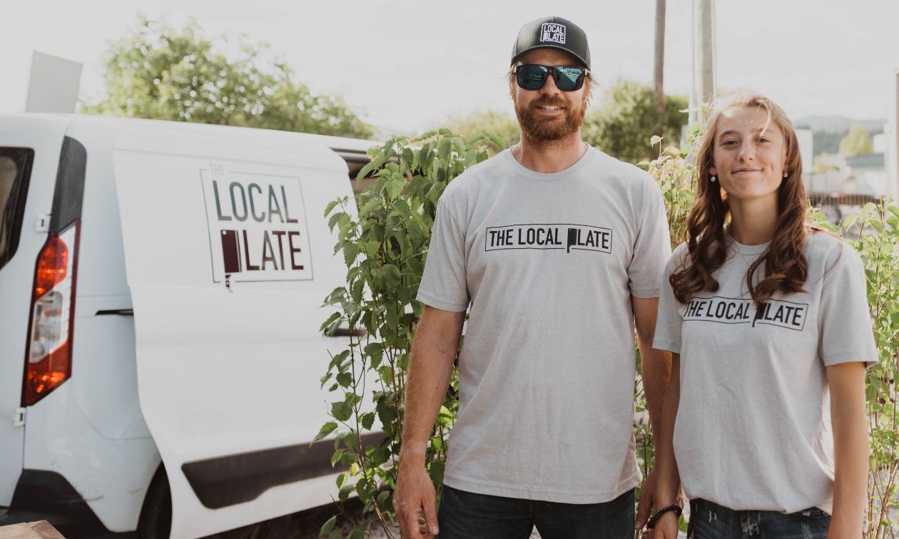 Jody McInnes and a woman stand next to their delivery van, which has the inscription of The Local Plate. 