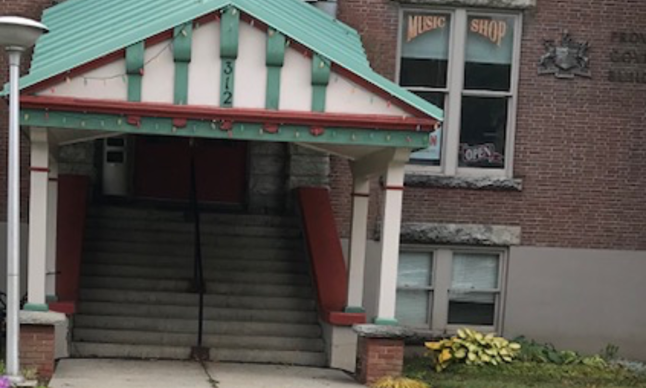 The Kemball Building in Kaslo, B.C., is brick-built with a green awning. 