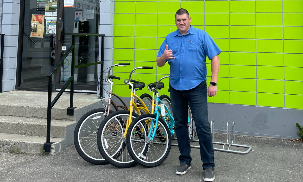 Jared Williams stands in front of Northstar Bicycle Co., a lime green building in Cranbrook, B.C.