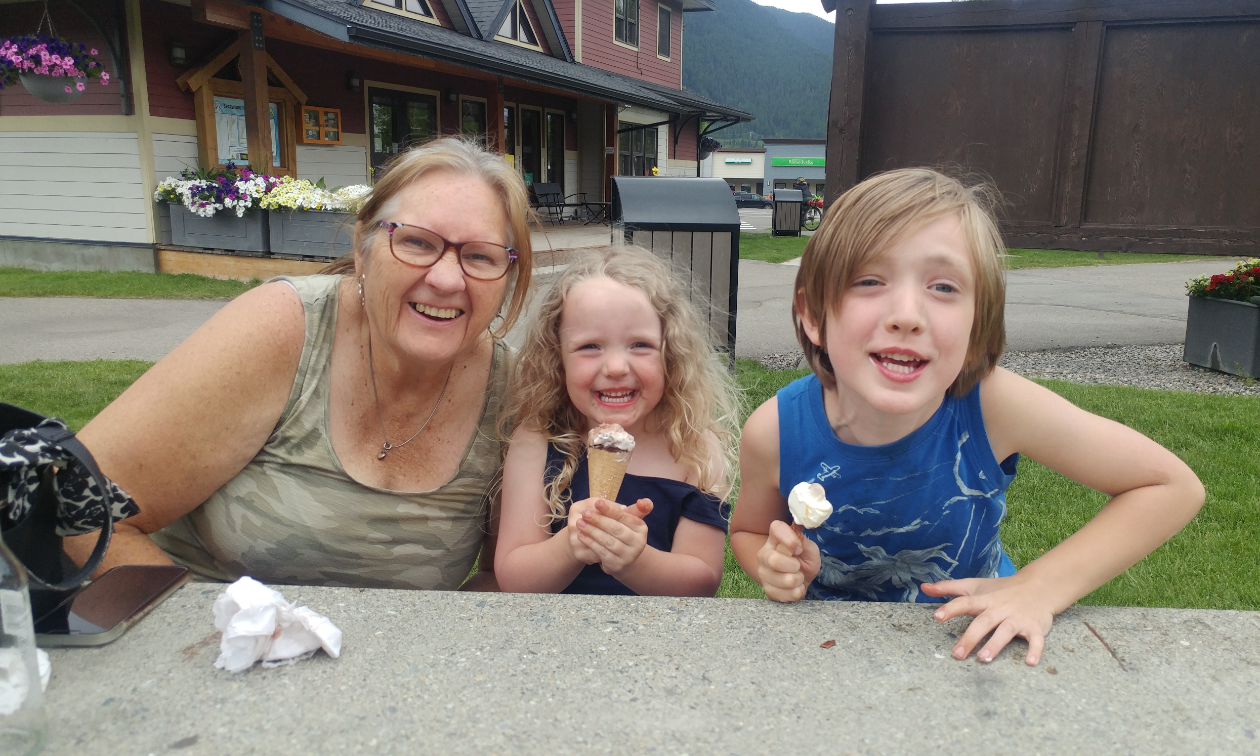 Ellie, Annabelle, and Gus Born smile happily while eating ice cream outside of the Sparwood Chamber of Commerce. 