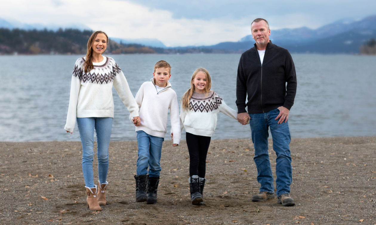 Bruce and Myriam Devlin and their two children walk along a shoreline. 