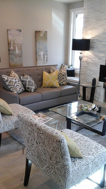 The living room at a staged home in inner city Calgary.  Grey couch with throw cushions as accents. 