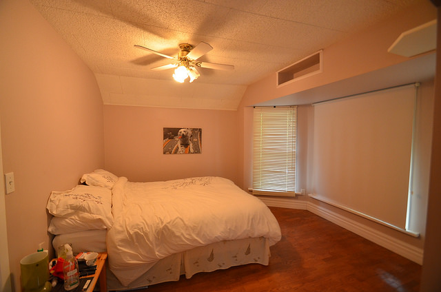 This bedroom hasn't been staged.  It is plain, and covers up the large windows with blinds. 