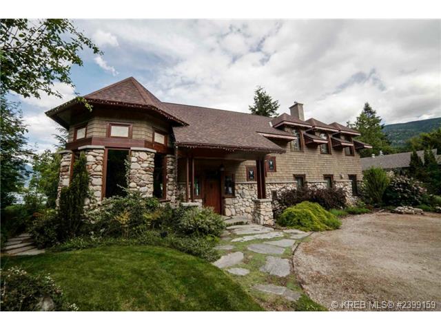 A stone-front home, with a long curving driveway in front of it