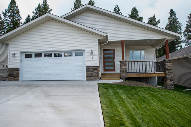 The exterior of New Dawn's award-winning home shows the unique front door with horizontal panes of glass alternating with  wood.