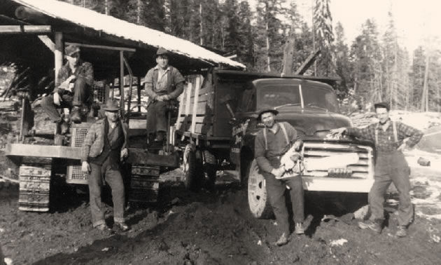 A black and white photo of a logging crew at camp. 