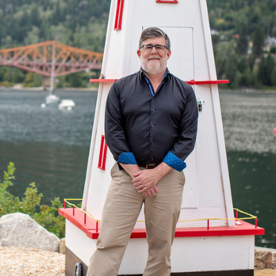 Colin White stands in front of an orange bridge in Nelson, B.C.