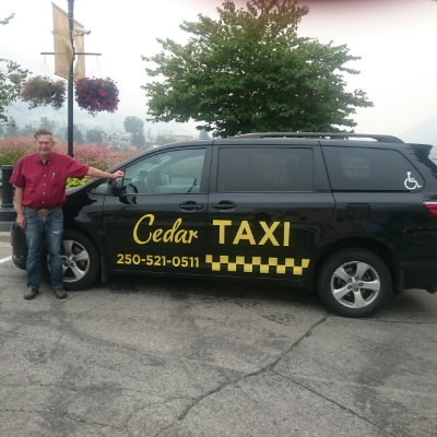 Ian Thomas stands next to his Cedar Taxi van