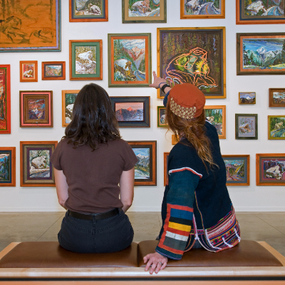 Picture of two people looking at paintings in an art gallery. 