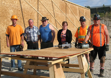 A group of people standing in front of the new Cranbrook Food Bank Warehouse construction site.