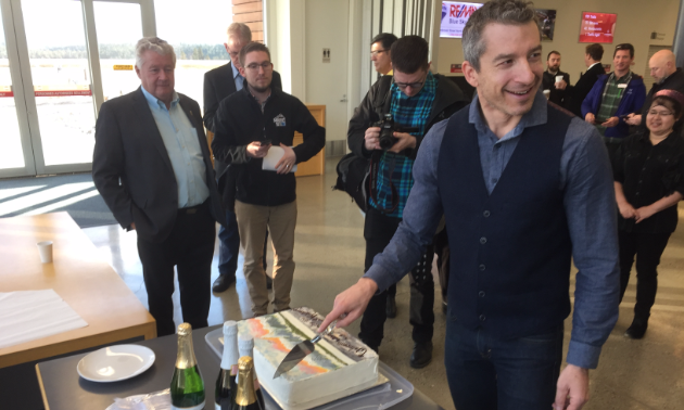 Tristen Chernove, CEO of Elevate Airports, cuts celebratory cake at announcement that WestJet and Pacific Coastal Airlines have partnered to bring jet service (Calgary to Cranbrook) to Canadian Rockies International Airport.