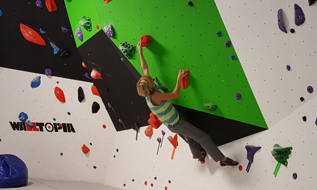 A child climbs a wall at Arq Mountain Centre. 