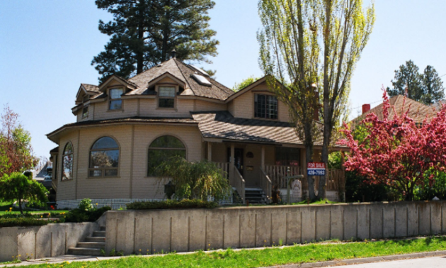 Baker Hill Heritage Bed and Breakfast is a large brown house with many windows and colourful trees in the yard. 