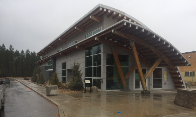 The old Golden Visitor Info Centre is grey with wooden supports holding up an awning.