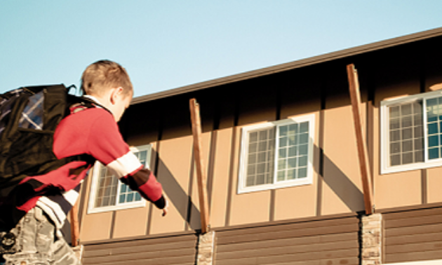 A child runs towards a building. 