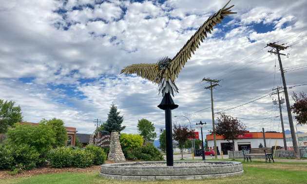 A large eagle made of steel framework resides next to a Welcome to Cranbrook sign.