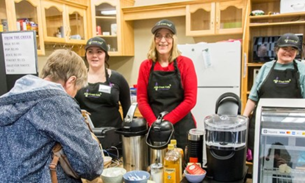 Workers at Java Creek Café welcome a customer.