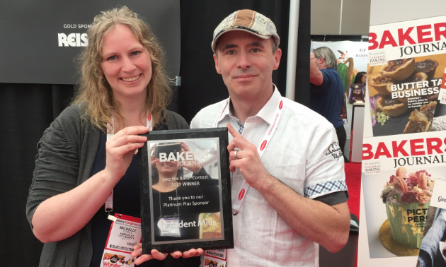 Michelle and Eric Forbes smile while holding their award for the prestigious Jake the Baker award from Bakers Journal magazine.