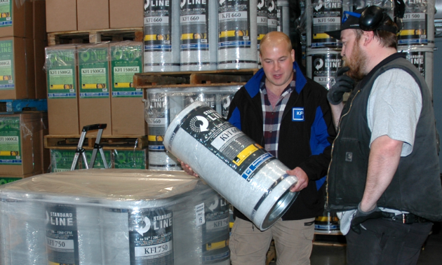 (L to R) Kyle Downey and Kyle Grattan, employees at Kootenay Filter Inc., look over products in their Nelson warehouse.