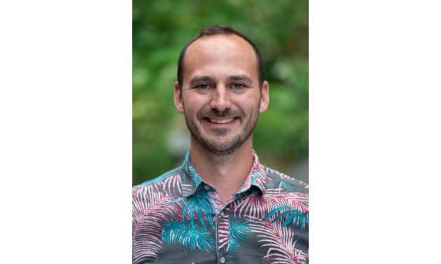 Mike Irvine smiles with a Hawaiian shirt on.