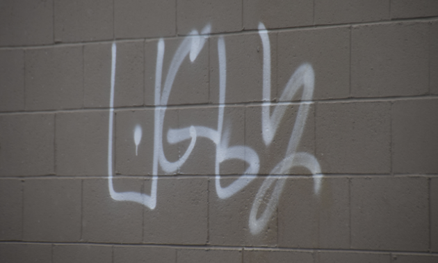 The word “ugly” is spray painted on a wall.
