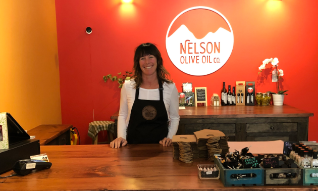 Michelle Rudell stands behind the counter in her store, Nelson Olive Oil.