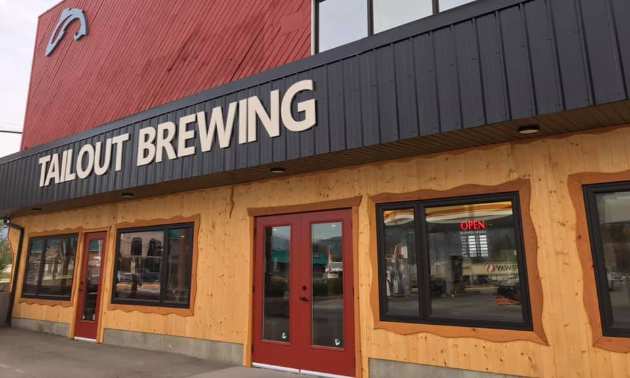 The front of Tailout Brewing is beige with maroon accents and a brown roof. 