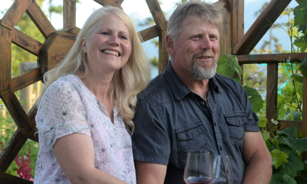 Jody and Brenda Scott smile while holding glasses of wine.