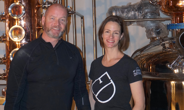 Andrew Hayden and Jillian Rutherford stand together in their distillery. 