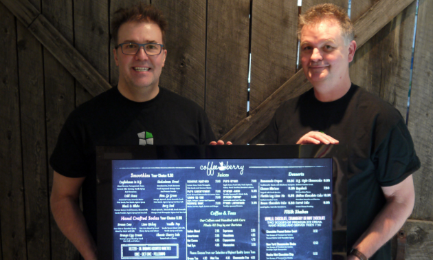 (L to R) Tony Wagner and Markus Doerner, owners of Flook Digital Media pose with one of their digital sign boards.