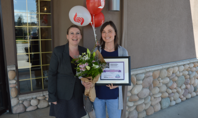 (L to R) Amie Lubbers, sales co-ordinator for Kootenay Business magazine, presents one of three Influential Women In Business awards to Stephanie McGregor, owner of The Paw Shop in Cranbrook. 