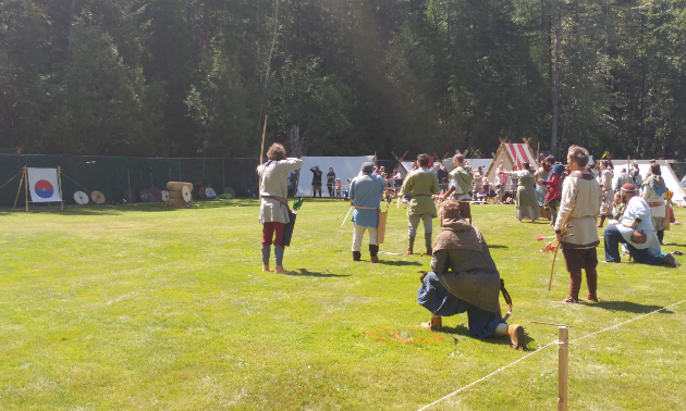 Archers shoot arrows at targets.