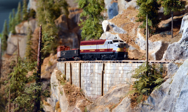 A toy train car rides along a track.
