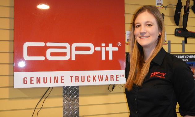 Nicole Kauffman poses next to a Cap-it sign