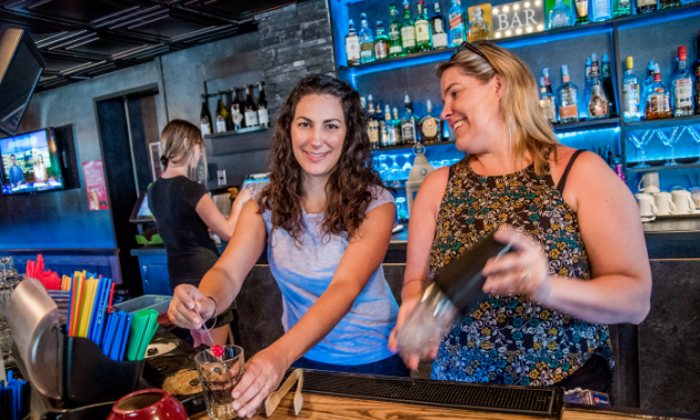 Staff members make drinks for customers