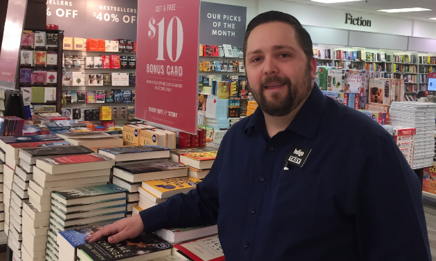 Tasy Strouzas stands inside Cole's Bookstore next to a collection of books