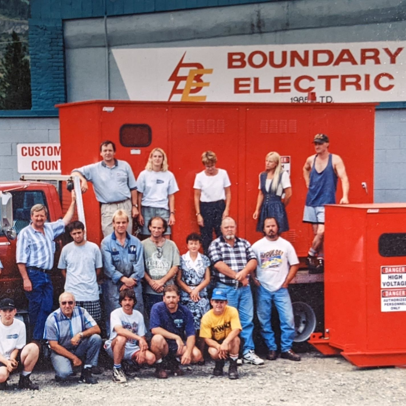 A group of employees pose in front of Boundary Electric in an old photo. 