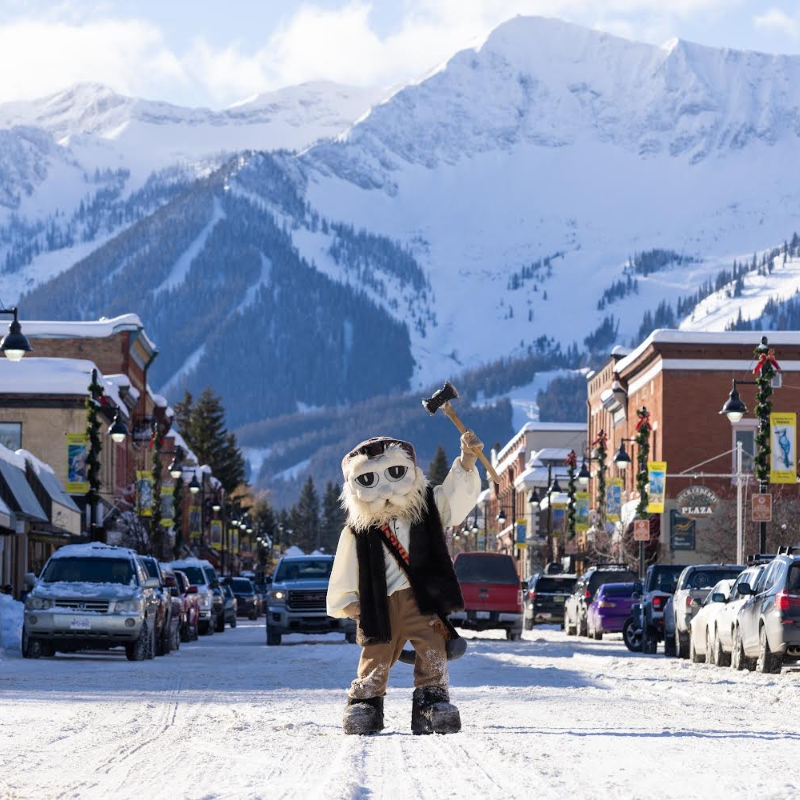 A sasquatch-costumed Taylor Jenkins stands on a snowy main street downtown Fernie. 
