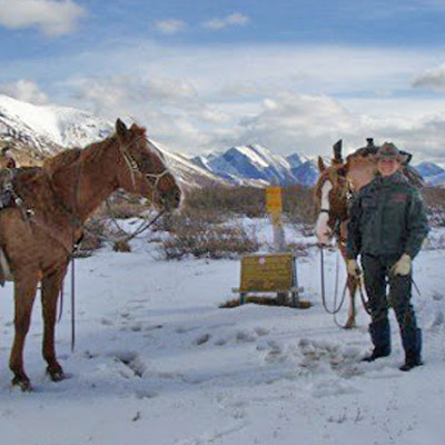 Amber Granter with two horses, mountains in background. 