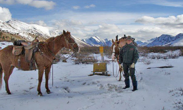 Amber Granter with two horses, mountains in background. 