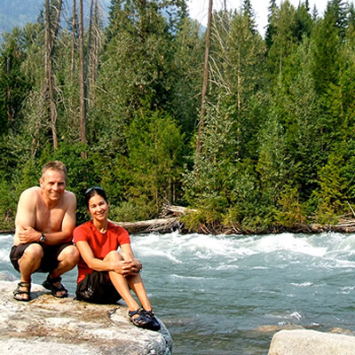 Ralph and Debbie Koerber sitting beside a river. 