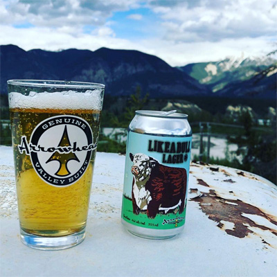 Glass of Arrowhead lager and beer can.