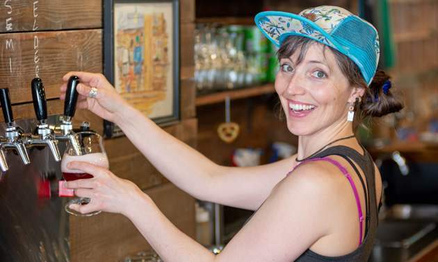 Staff member at Backroads Brewing, Keltie, pours from one of the pub's taps